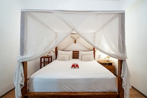 A bed with a canopy, wooden headboard, and bedside tables.