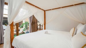 Un dormitorio amplio con una cama grande, ropa de cama blanca y un dosel.