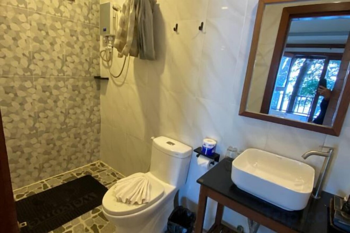 A bathroom with a toilet, sink, and a mirror.
