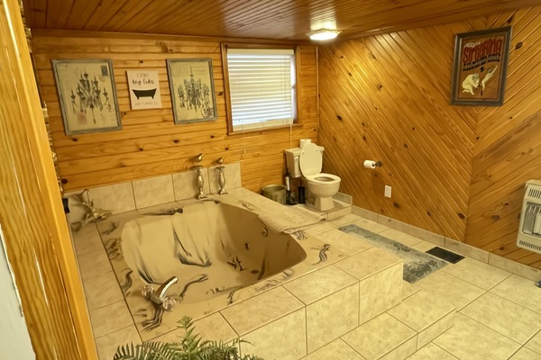 Een bad/douchecombinatie, handdoeken, toiletpapier