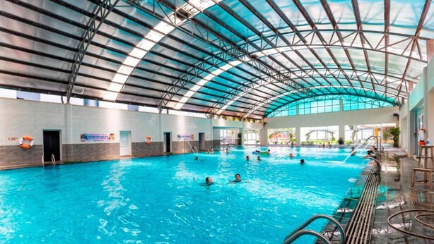An indoor swimming pool with a high, arched roof structure.