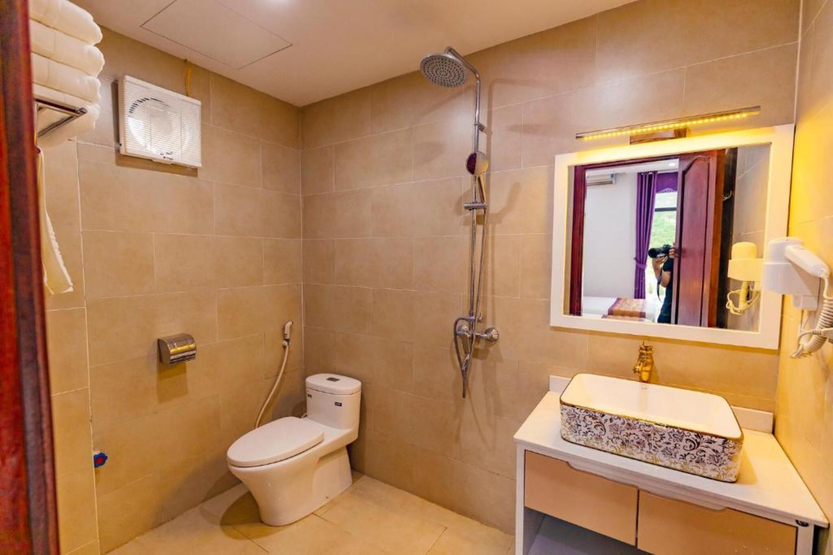 Un baño con inodoro, ducha, lavabo y espejo.