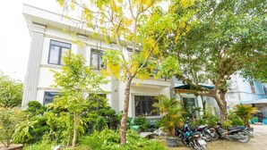 A building with a garden area, potted plants, and parked motorcycles.