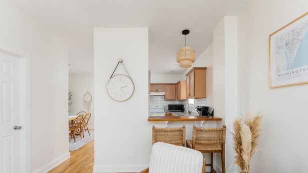 Una cocina moderna con armarios de madera, un microondas y una lámpara colgante.