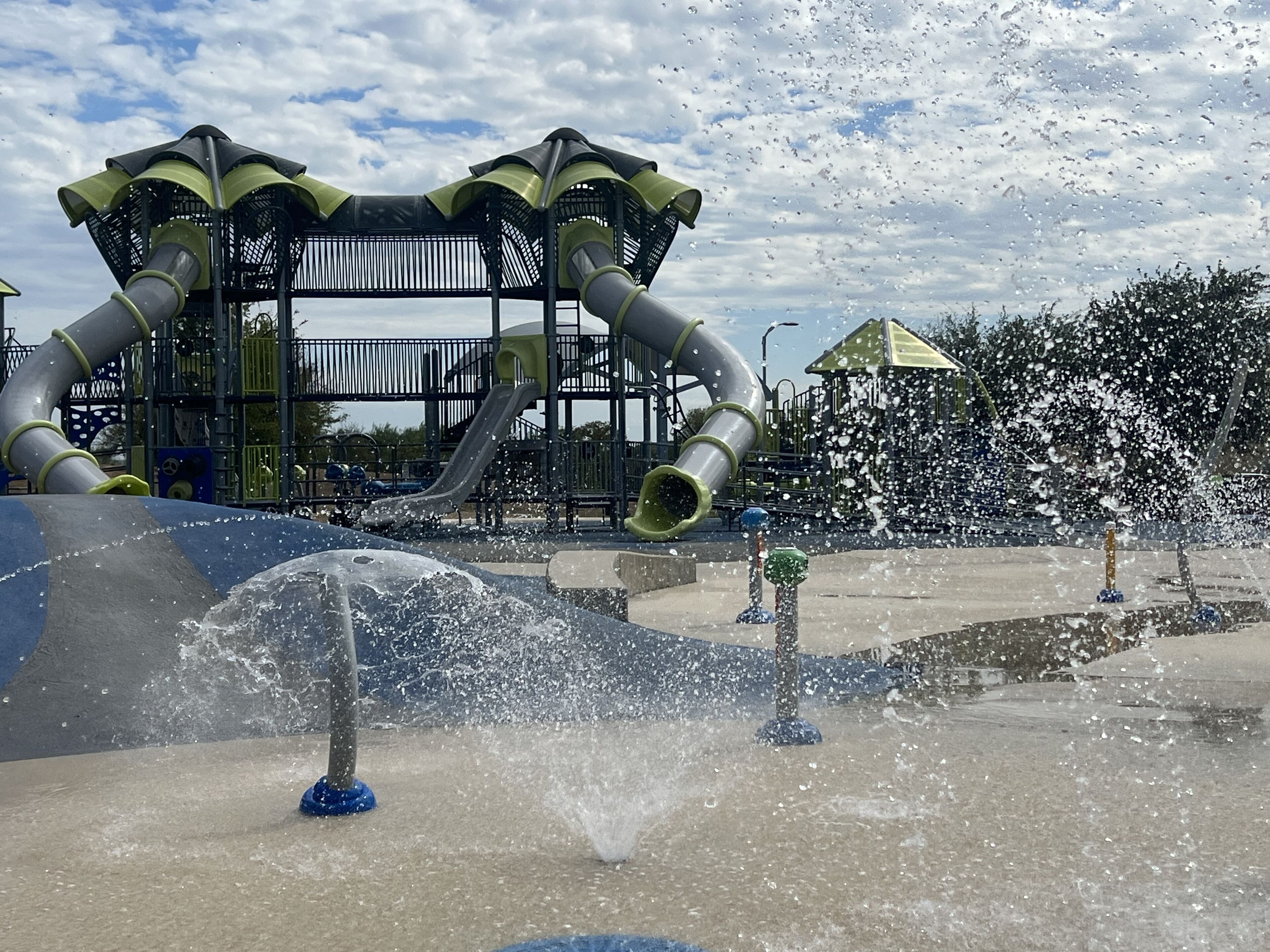 A water play area with multiple slides and water jets.