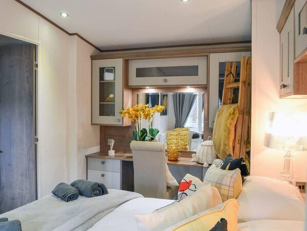 Un dormitorio acogedor con cama, mesita de noche y espejo.