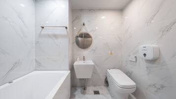 Un baño moderno con bañera, lavabo e inodoro.