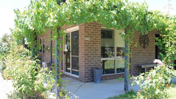 A brick building with a reception area, large windows, and a covered outdoor seating area. - Chalambar Motel (Ararat)