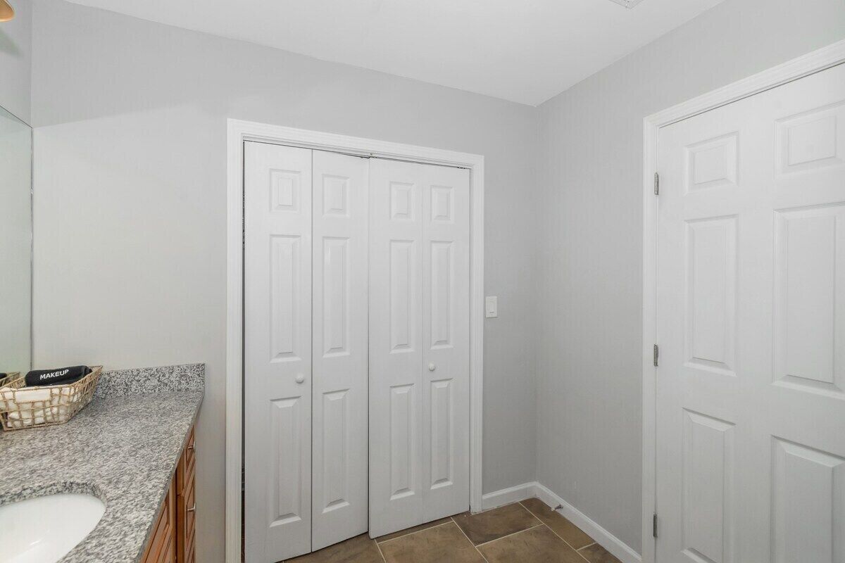 A bathroom with a white sink, a mirror, and a white door.