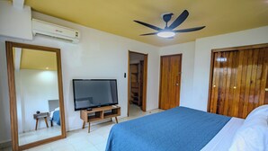 A bedroom with a bed, a television on a wooden stand, a ceiling fan, and a wardrobe. - Charming 3BR 3BTH Stay • Close to Tortugas Beach (Cancún)