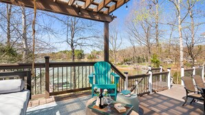 A wooden deck with a pergola, outdoor seating, and a view of a lake and trees. - Shoreside Oasis - Amazing Views & Spacious 5BR 4BA (Mooresville)