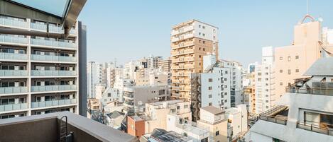 A high-rise building with multiple balconies and a clear view of the cityscape.