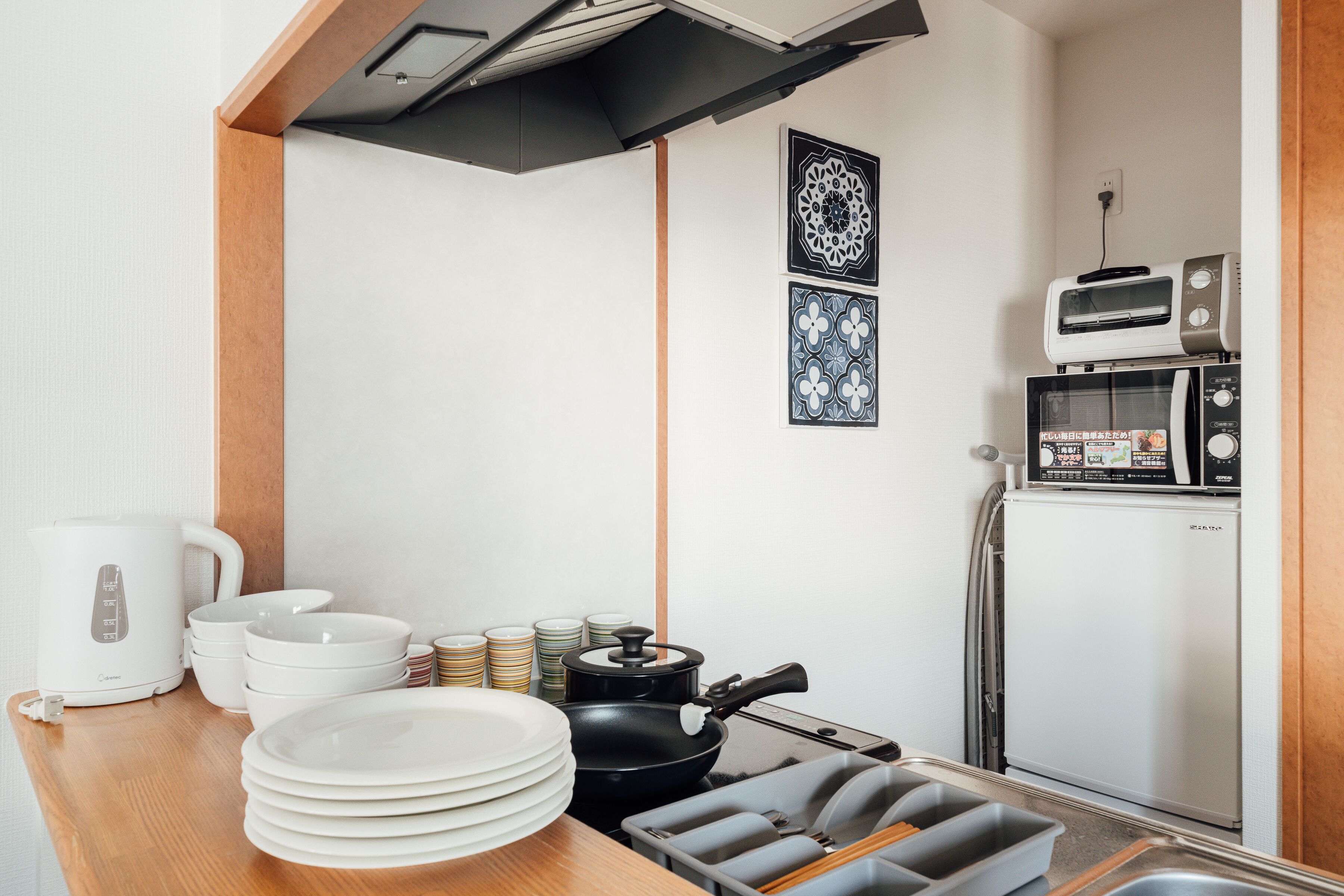 A compact kitchenette with a stove, microwave, and toaster.