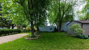 A residential property with a well-maintained lawn, a driveway, and a small shed.