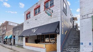 A building with a storefront labeled "Vine Shop - Fine Foods - Gourmet Grocery - Craft Beer".