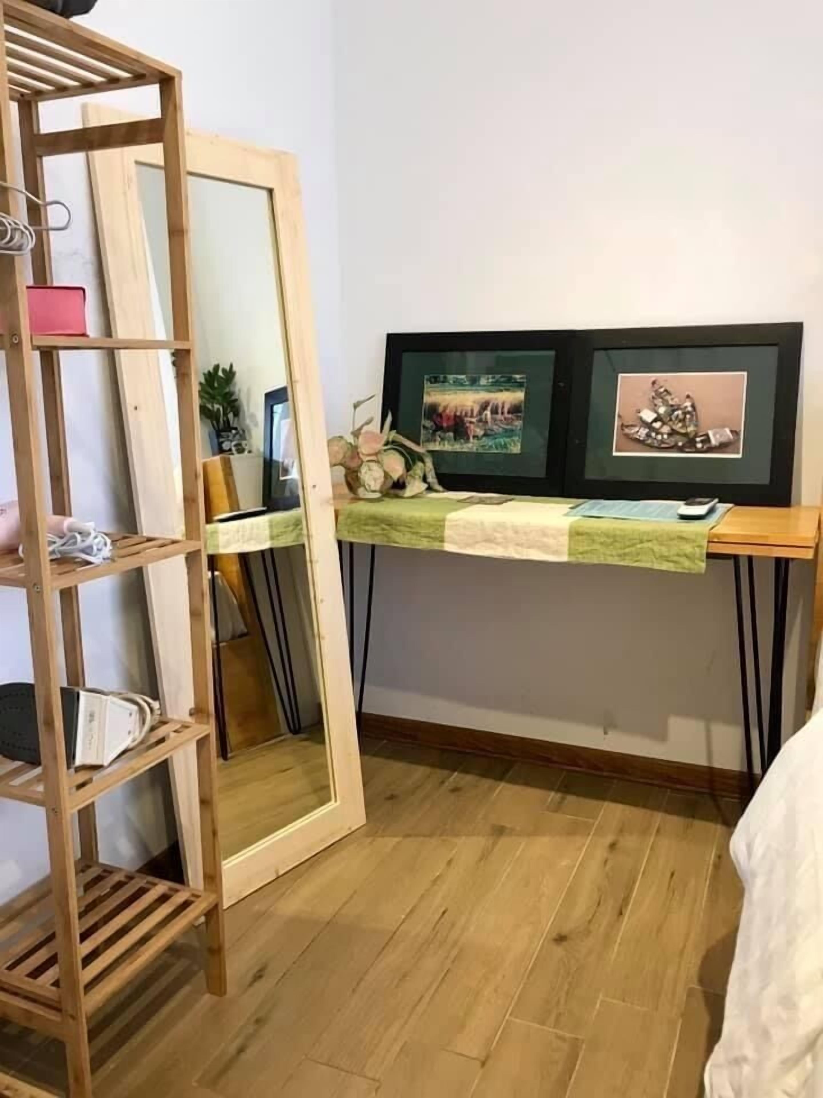 Een kamer met een houten ladder, een bureau met een groene kleed en twee prestaties aan de muur.
