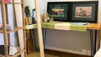 Een kamer met een houten ladder, een bureau met een groene kleed en twee prestaties aan de muur.