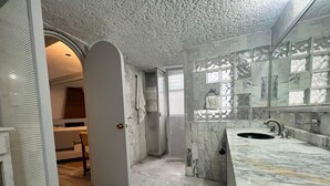 A modern bathroom with a marble sink, a glass shower enclosure, and a marble-tiled wall. - beautiful apartment in polanco (Ciudad de México)