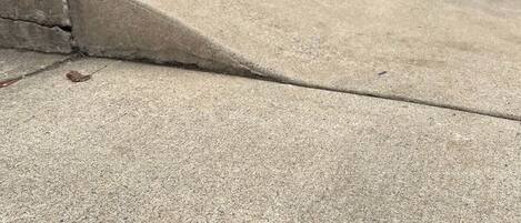 Una acera de concreto con una leve grieta.
