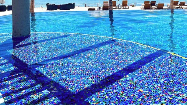 An infinity pool with a view of the ocean, palm trees, and lounge chairs. - Quinta with ocean and golf course panoramic views (La Paz)