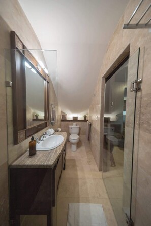 Une petite salle de bain avec un lavabo double, des toilettes et une douche Ă parois de verre.