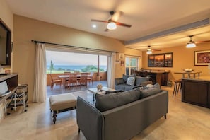 A spacious living area with a sofa, a dining table, and a kitchen area.