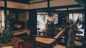 A cozy interior with a fireplace, wooden furniture, and various plants. - La Terra Nagano (Shiojiri)