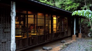 A traditional Japanese-style building with large windows, a wooden exterior, and a stone pathway leading to the entrance. - La Terra Nagano (Shiojiri)