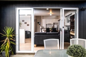 Cozy living space with a sofa, glass table, and compact kitchen area.