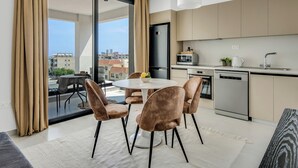 A modern kitchen with a dining area, large windows, and a view of the city. - Sanders Elgio - Adorable Studio with Balcony (Agios Athanasios)