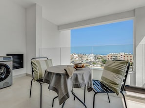 Enjoy a peaceful city view from this balcony with a round table and two chairs.