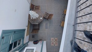 Ein mehrstöckiges Wohngebäude mit Treppe, Außenbereich mit Sitzgelegenheiten und einem Fenster mit Vorhang.