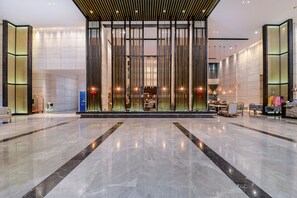 A spacious lobby with a polished marble floor, a reception desk, and seating areas. - MANDARIN HOTEL (Jiangmen)