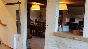 Una habitación con chimenea, una mesa de comedor con sillas y un radiador.