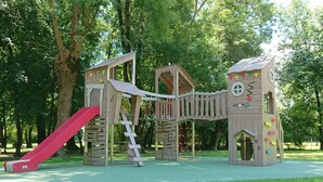 A wooden play structure with a slide and climbing elements in a park. - Renovated house near Angoulême with private garden (Vindelle)