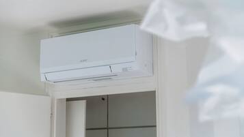 A white air conditioning unit mounted on a wall above a doorway.