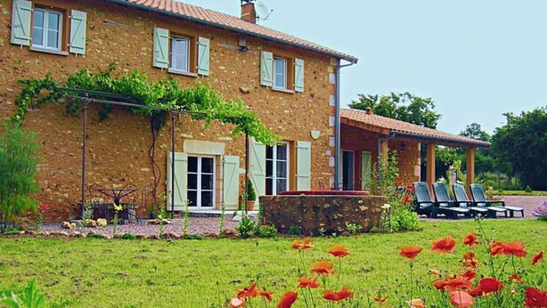 A stone house with a garden and outdoor seating area. - La Queue Rousse Cottage - Historic Home with Fireplace and Enclosed Garden (Vitrac-Saint-Vincent)