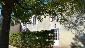 A building with a paved pathway, a small tree, and a hedge. - Family cottage in village, pets allowed (Salles-Lavalette)