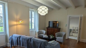 Una habitación acogedora con una cama, televisión y zona de comedor.
