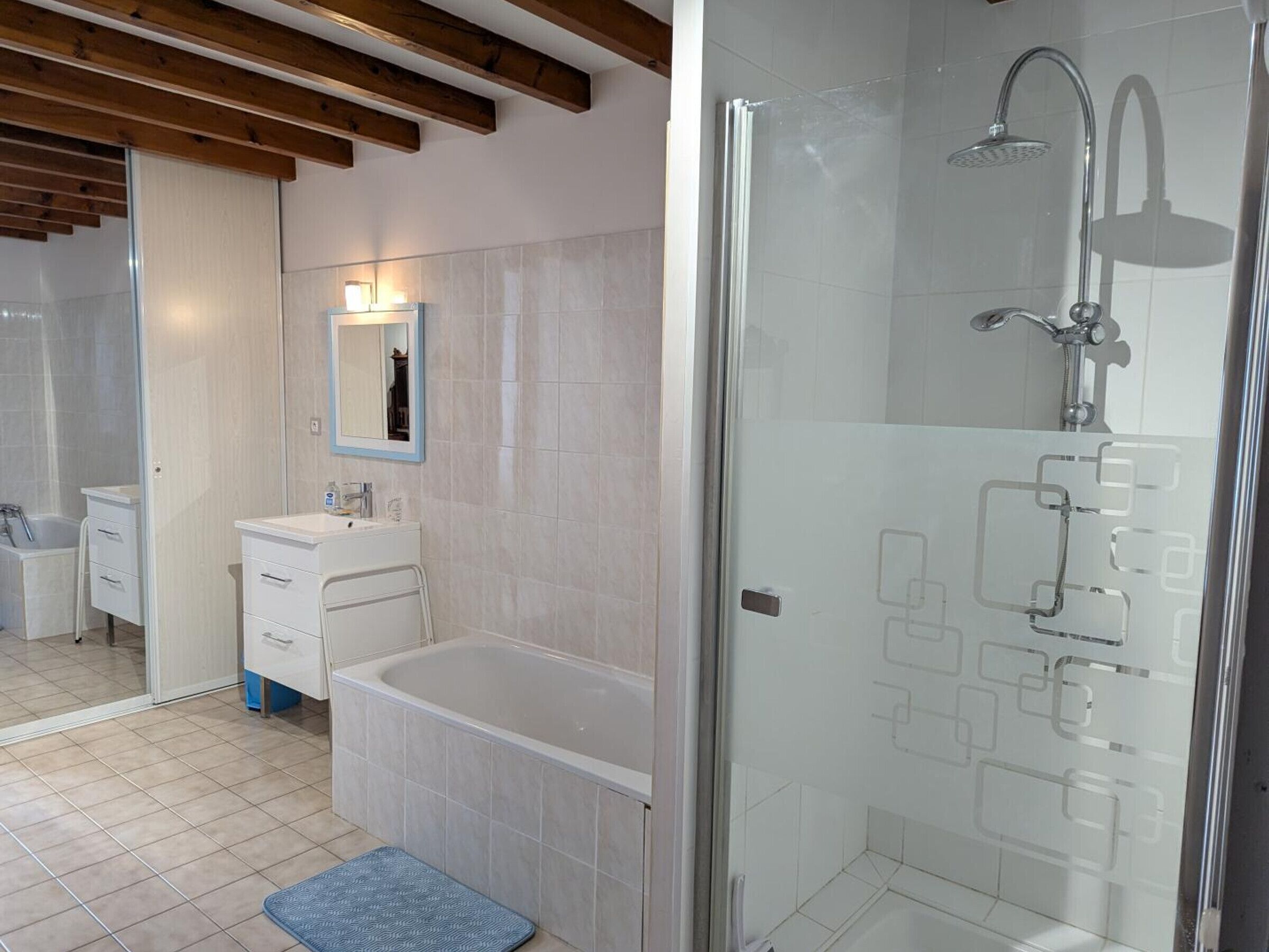 Casa de banho moderna com banheira, chuveiro e toucador com espelho.