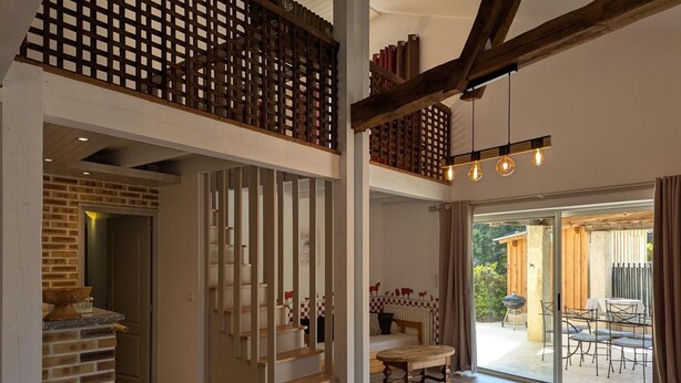 A spacious interior with a staircase, a dining area, and a view through a glass door. - Charming Cottage with Heated Pool and Private Garden in Charras, Near Périgord (Charras)