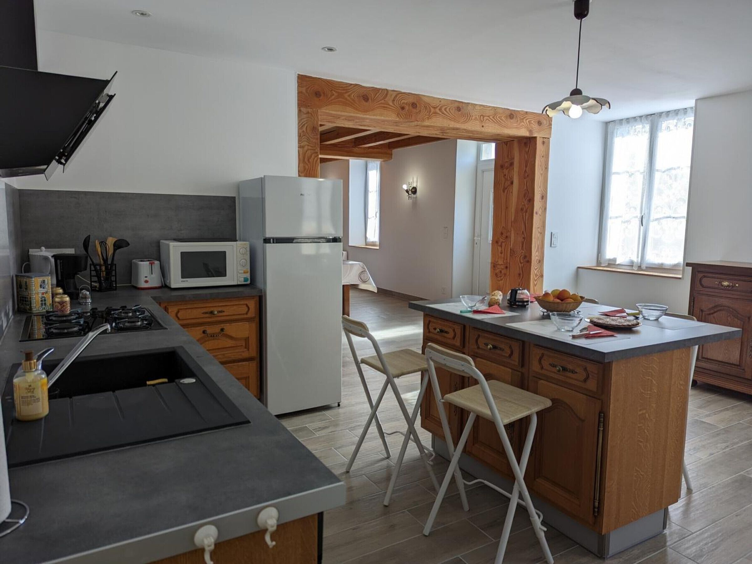 Une cuisine moderne dotée d’un îlot central, d’un four à micro-ondes, d’un réfrigérateur et d’une cuisinière à gaz.