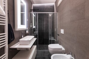 Regadera, amenidades de baño de diseñador, secadora de cabello, toallas 