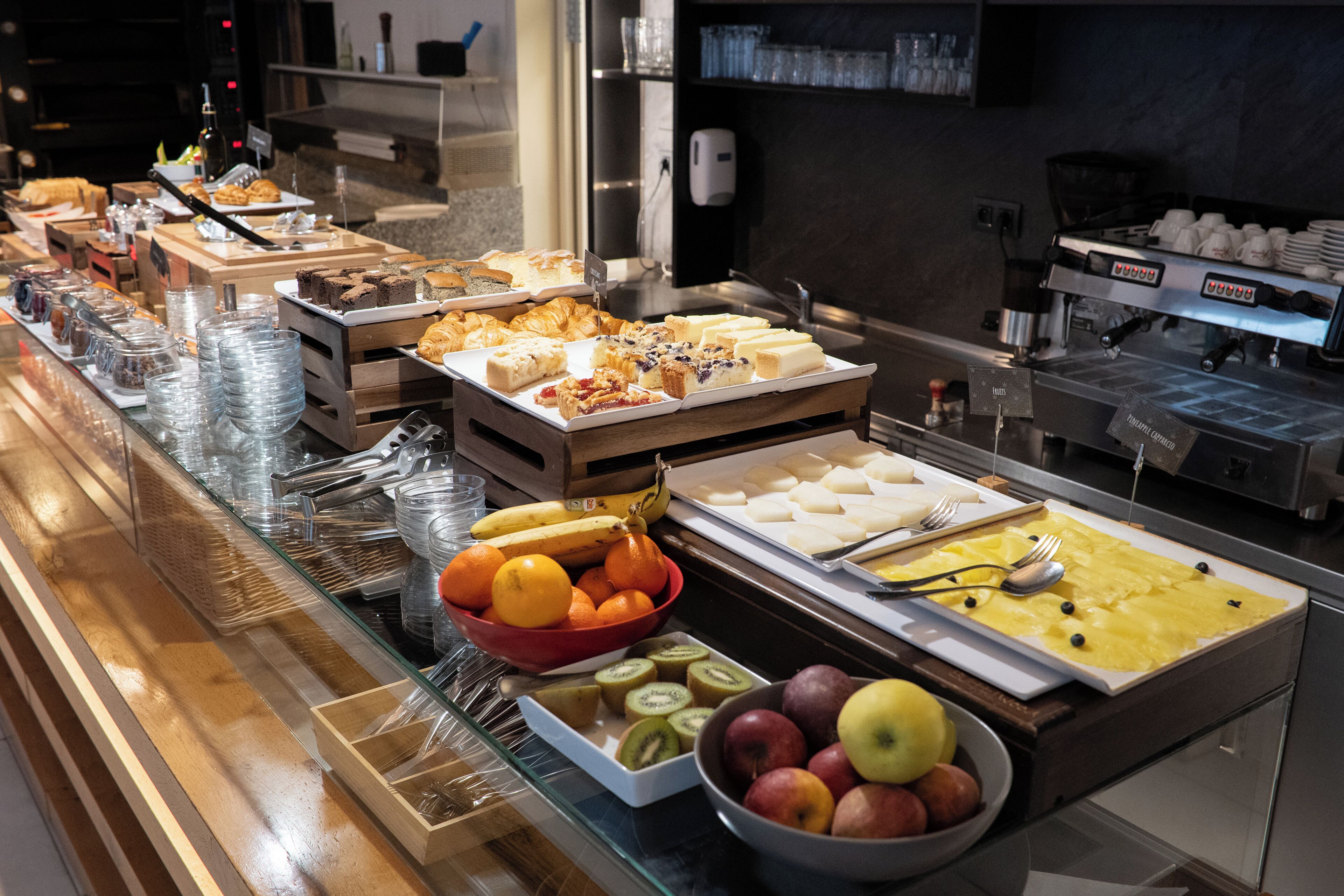 A buffet with various food items and a coffee station.