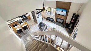 A modern interior with a staircase, a kitchen, a living area with a fireplace, and a TV. - Canyons Resort - Walking Distance Sunrise Gondola! (Park City)