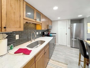 A modern kitchen with wooden cabinets, a stainless steel sink, and a refrigerator. - Canyons Resort - Walking Distance Sunrise Gondola! (Park City)