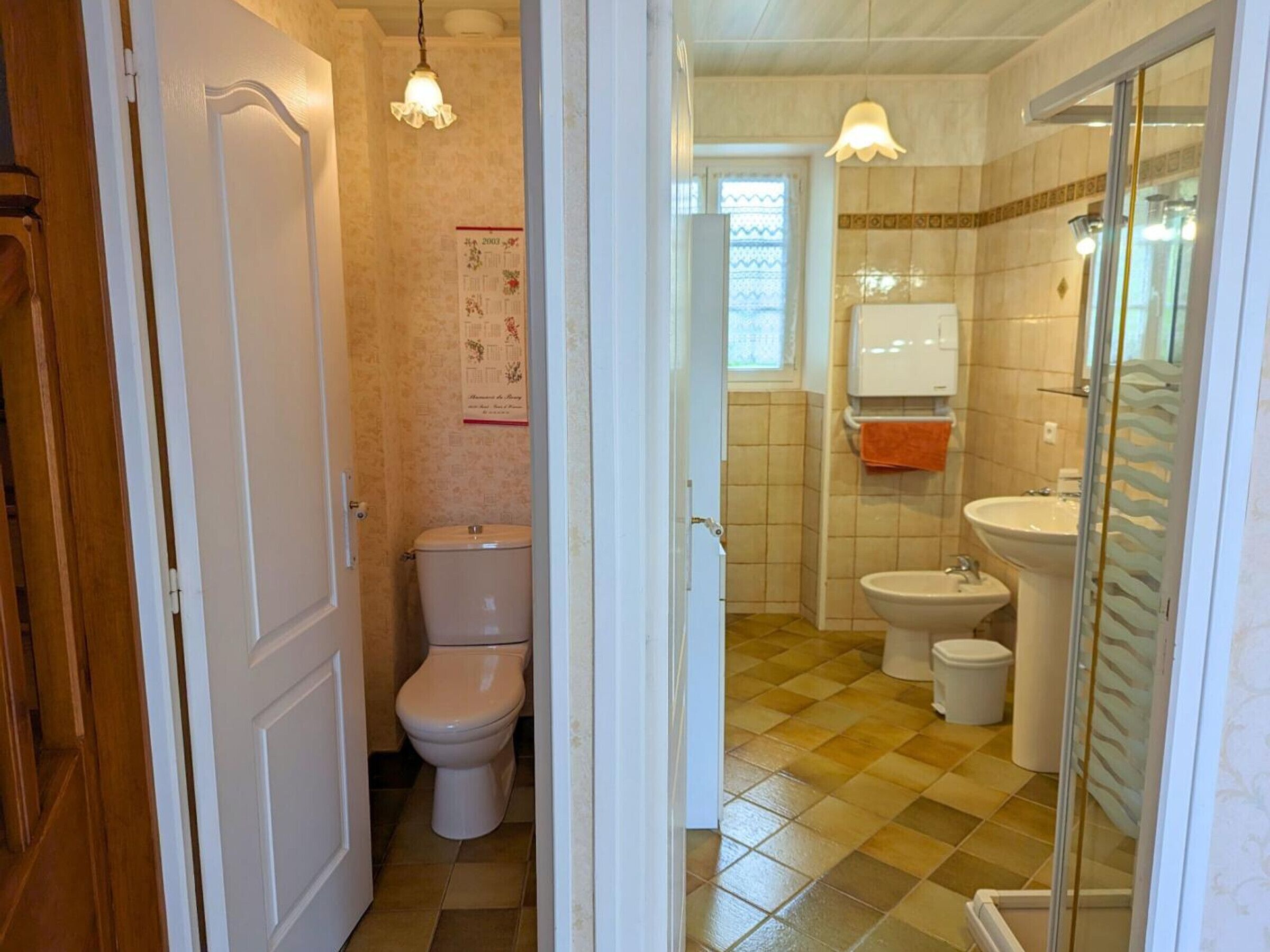 A bathroom with a toilet, bidet, and sink.