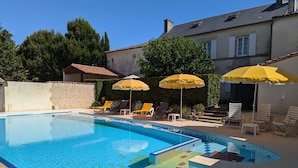 A swimming pool with lounge chairs and yellow umbrellas. - Charming Cottage with Pool, Fireplace, and Garden in Vineyard Estate (Saint-Cybardeaux)