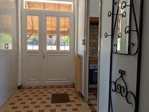 A hallway with a double door, a patterned floor, and a metal decorative element.