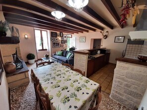 Un espace de vie chaleureux comprenant une table à manger, un canapé et un coin cuisine.